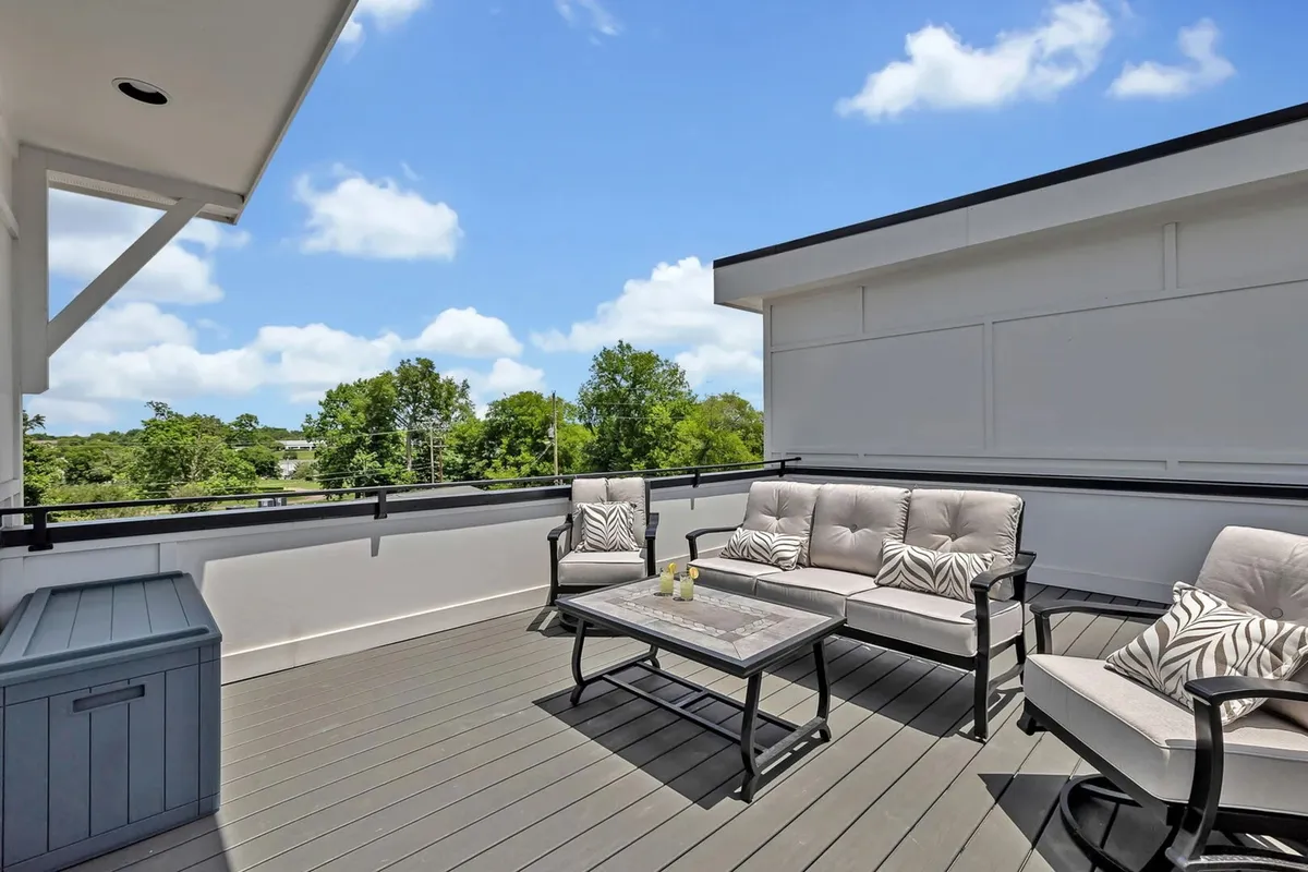 This rooftop features a comfortable seating area and a decorative table, surrounded by greenery and with a view toward the skyline. The ambiance is tranquil and intimate, ideal for sunset views, stargazing, or simply relaxing with friends or family.