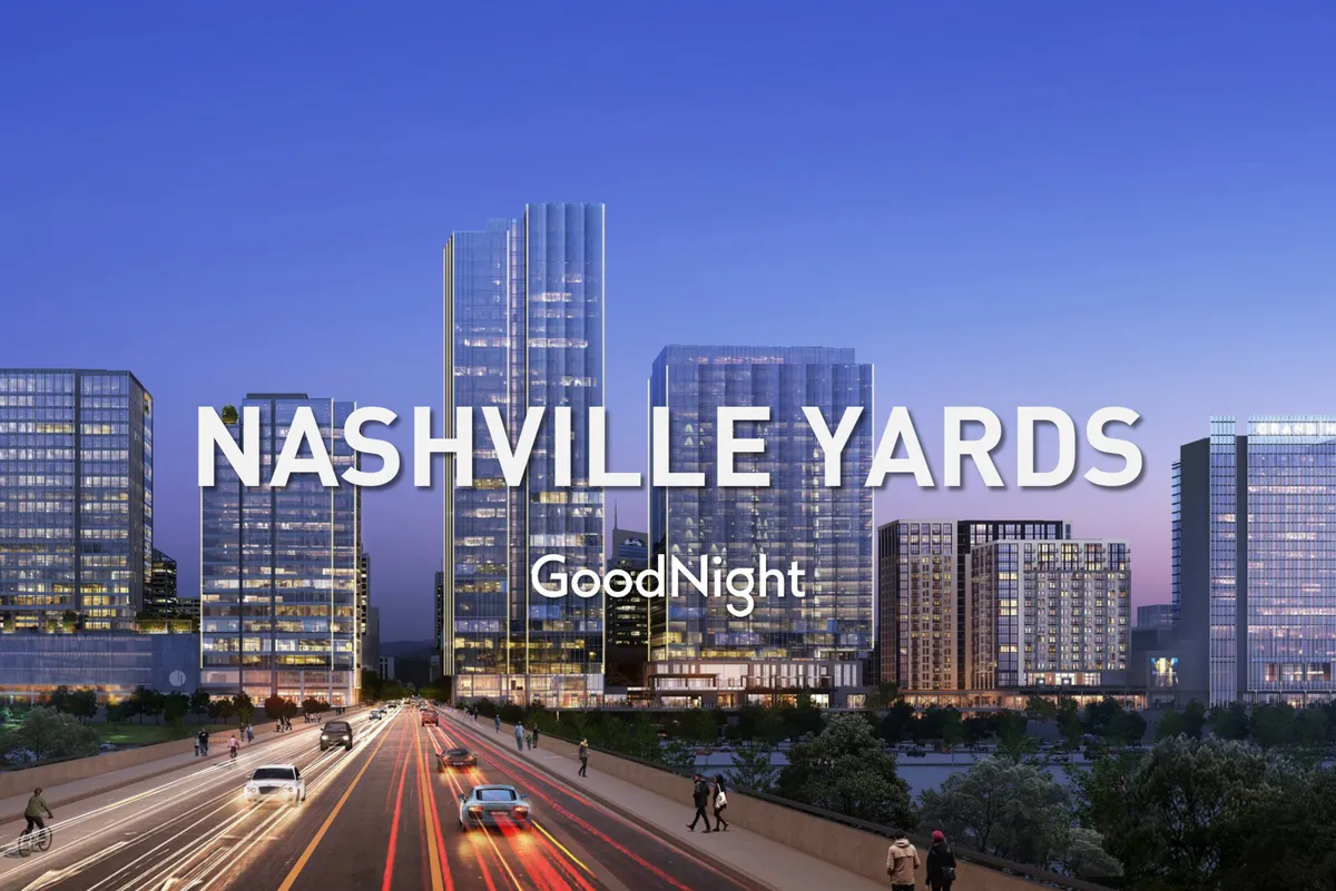 This image captures Nashville's vibrant city skyline at night with tall modern skyscrapers, illuminated buildings, and a busy roadway bustling with activity. The overall atmosphere is energetic and urban, evoking the excitement and nightlife of downtown Nashville.