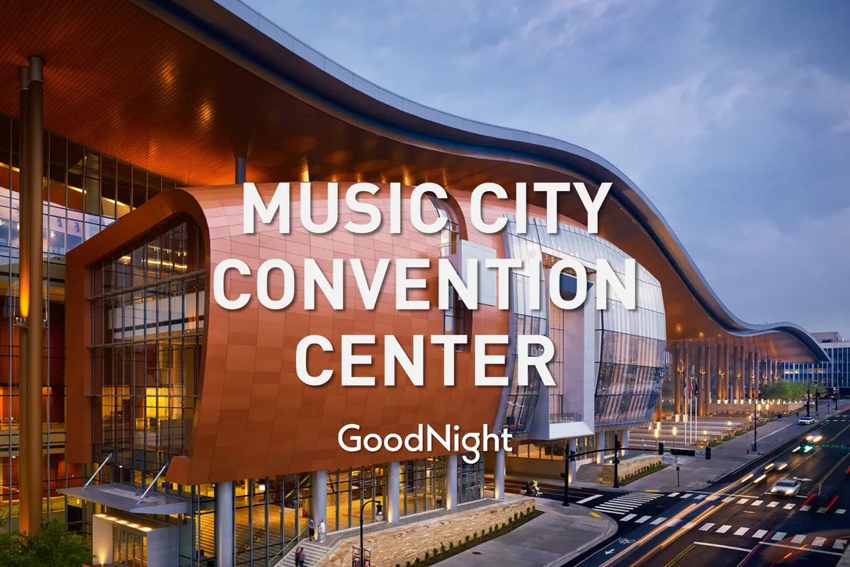 A striking view of modern architecture with a prominent curved roof and expansive glass windows. The building, likely a conference or cultural center, is bustling with activity, suggesting opportunities for professional gatherings, collaboration, and large events.
